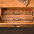 Two adjustable drawer dividers installed in a wooden drawer
